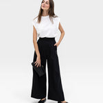 JONES + CO black high-waisted wide-leg cotton trousers with pleats, paired with a white top.