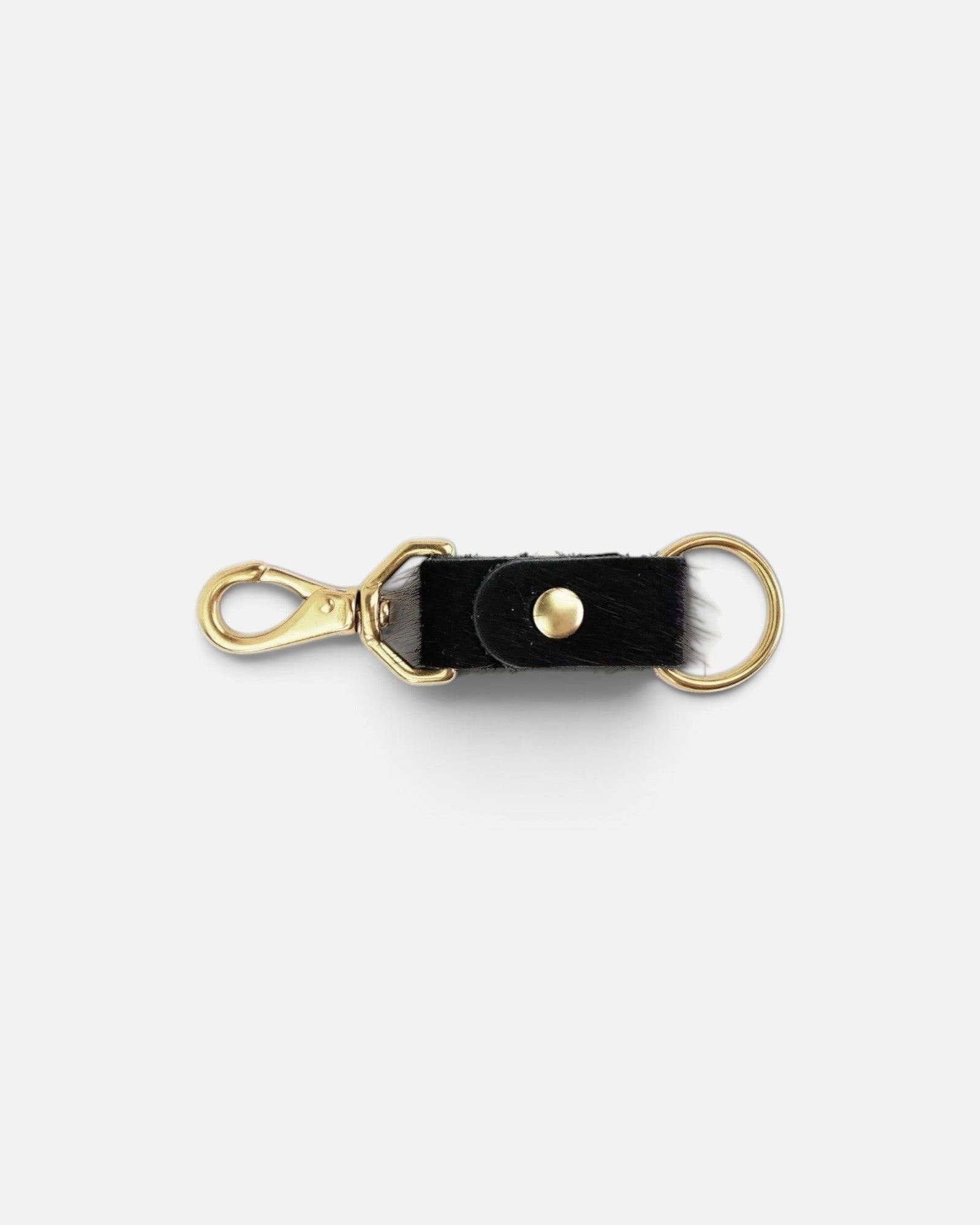 JONES + CO black cowhide keychain with gold-tone metal clasp and ring hardware on a white background.