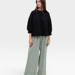 JONES + CO black crewneck sweatshirt with drop shoulders, raw edge hem, and distressed details.