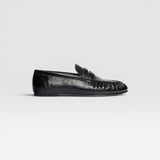 JONES + CO Sydney black crinkle patent leather penny loafer with ruched detailing on a side profile view.