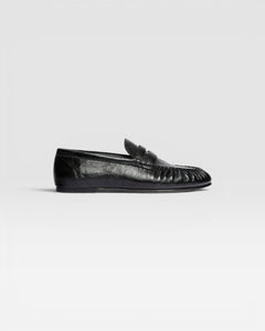 JONES + CO Sydney black crinkle patent leather penny loafer with ruched detailing on a side profile view.