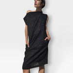 Model wearing a JONES + CO black embossed floral seersucker shift dress with an off-shoulder neckline and pockets.