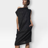 Model wearing a JONES + CO black embossed floral seersucker shift dress with an off-shoulder neckline and pockets.