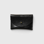 JONES + CO black pebbled leather cardholder with a minimalist envelope flap and gold stud closure.