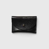 JONES + CO black pebbled leather cardholder with a minimalist envelope flap and gold stud closure.