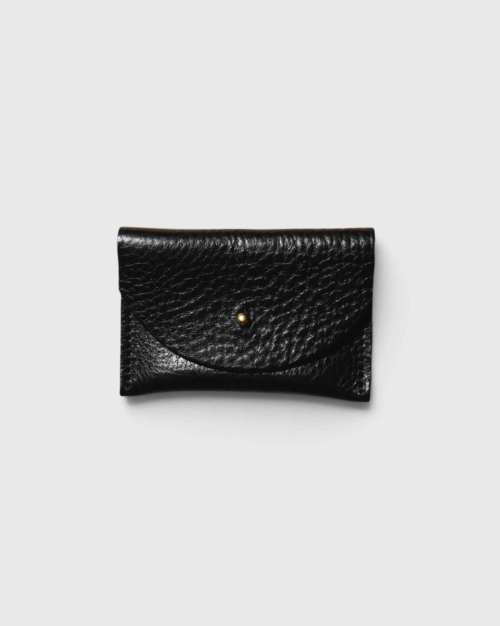 JONES + CO black pebbled leather cardholder with a minimalist envelope flap and gold stud closure.