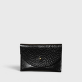 JONES + CO black pebbled leather cardholder with a minimalist envelope flap and gold stud closure.