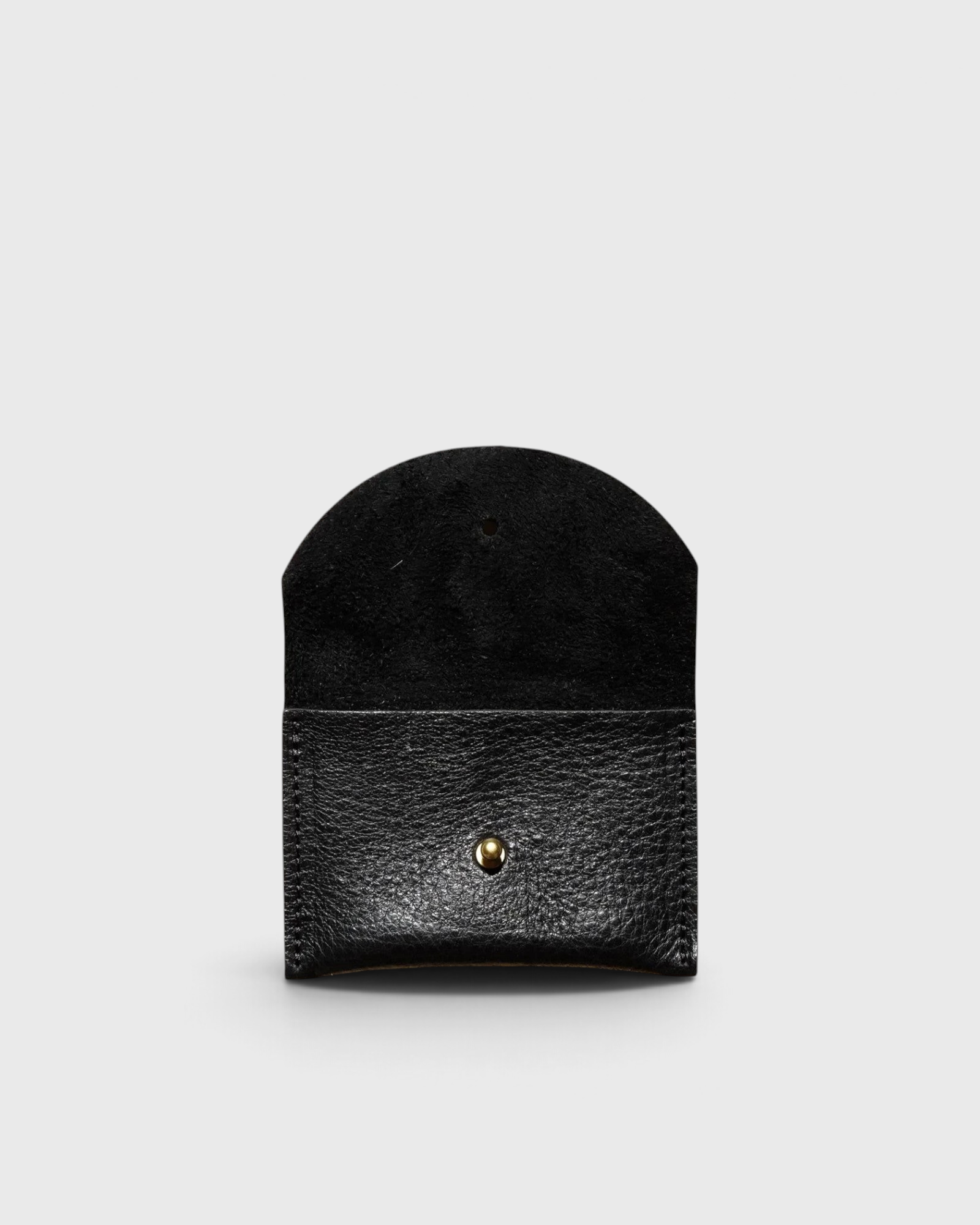 JONES + CO black leather cardholder with a rounded flap and gold snap button closure on a light grey background.