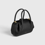 JONES + CO Oyster mini duffle bag in black pebble grained leather with gold-tone hardware and structured top handles.