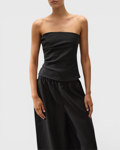 JONES + CO black strapless Alzira top in breezy linen with asymmetric front pleats worn by a model