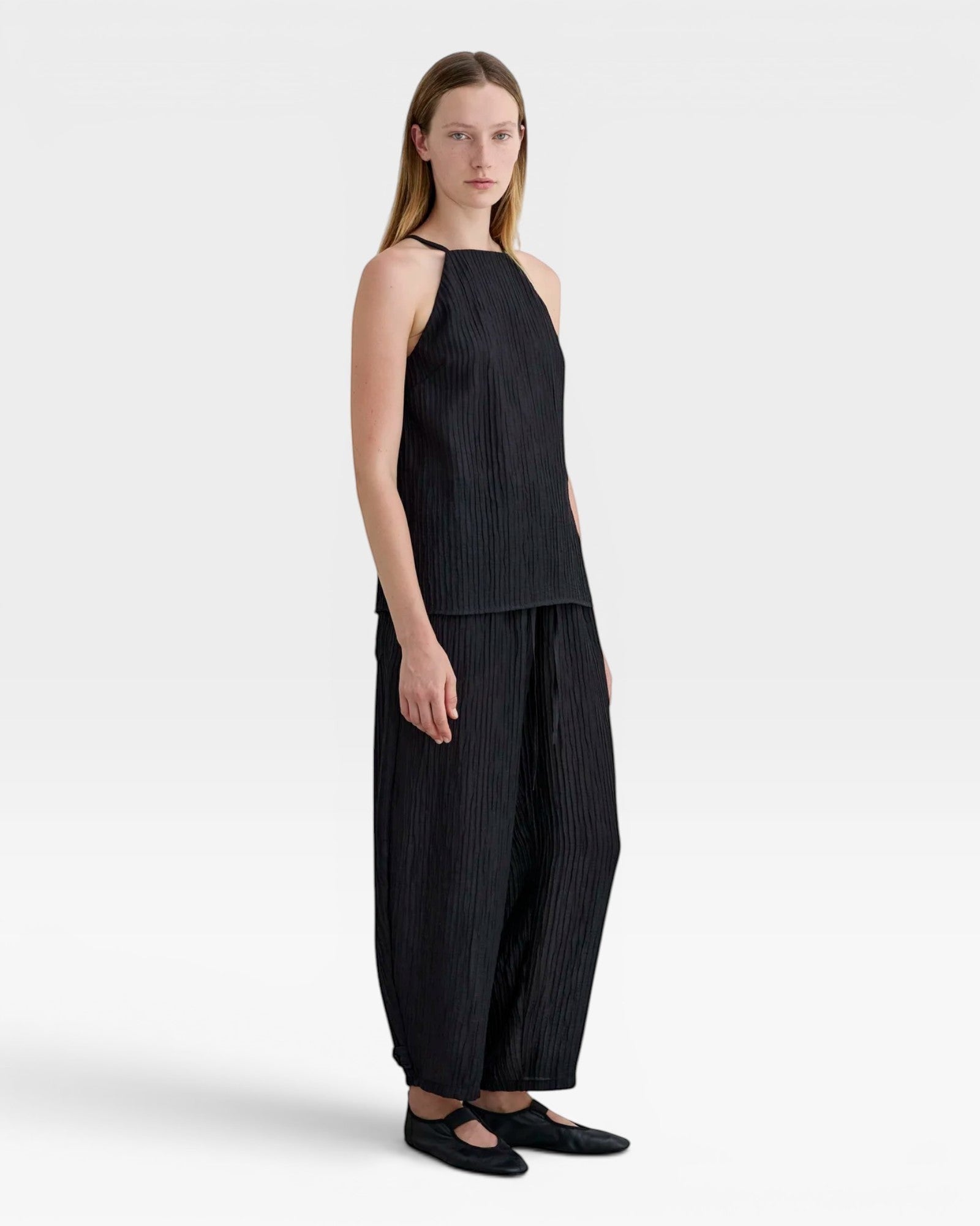JONES + CO black Lyocell blend wrinkle finish balloon-leg pull-on trousers with elasticated waistband and ankle buttons.