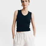 JONES + CO black ribbed knit tank top with a deep scoop neckline, paired with rust linen shorts.
