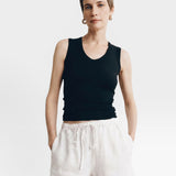 JONES + CO black ribbed knit tank top with a deep scoop neckline, paired with rust linen shorts.