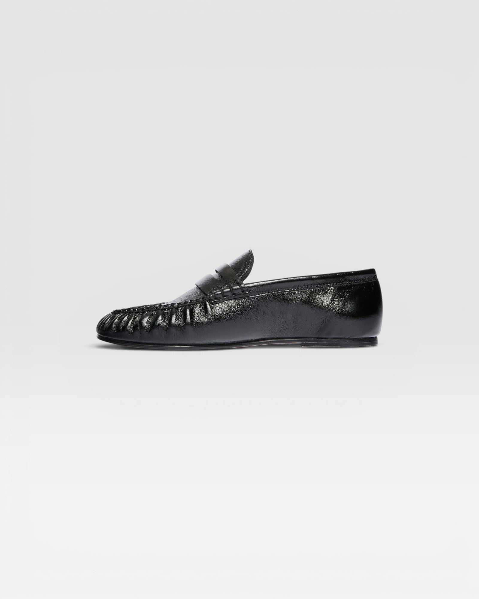 JONES + CO Sydney black crinkle patent leather penny loafer with ruched toe detail in a side profile view.