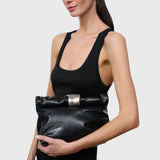 JONES + CO black snake-embossed leather slouchy clutch with a polished silver metal cuff handle held by a model.