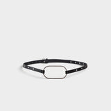 JONES + CO black crust leather belt with an oversized oval buckle and polished metal rivets along the slim strap.