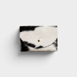 JONES + CO black and white cowhide cardholder with a solid brass fastener, featuring a natural hair-on-hide texture.