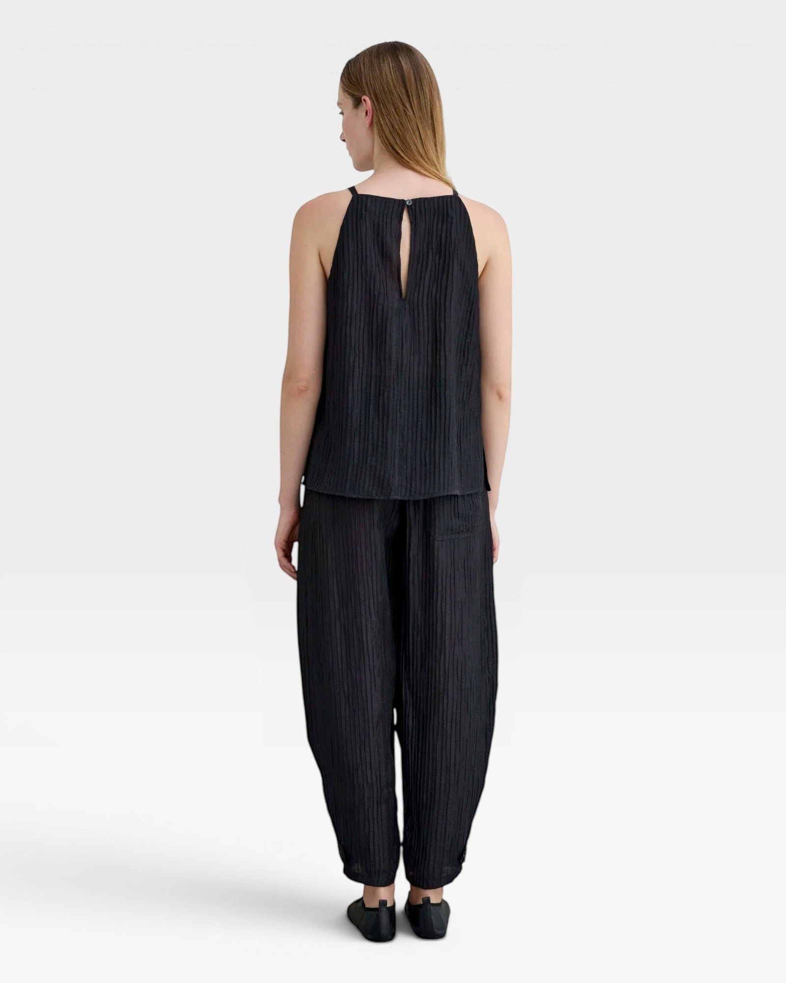 JONES + CO black Lyocell blend balloon-leg trousers with wrinkle finish and ankle button detail.