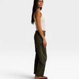 JONES + CO Blondie bright ivory ribbed tank top worn by a model in profile with olive green pants and sandals.