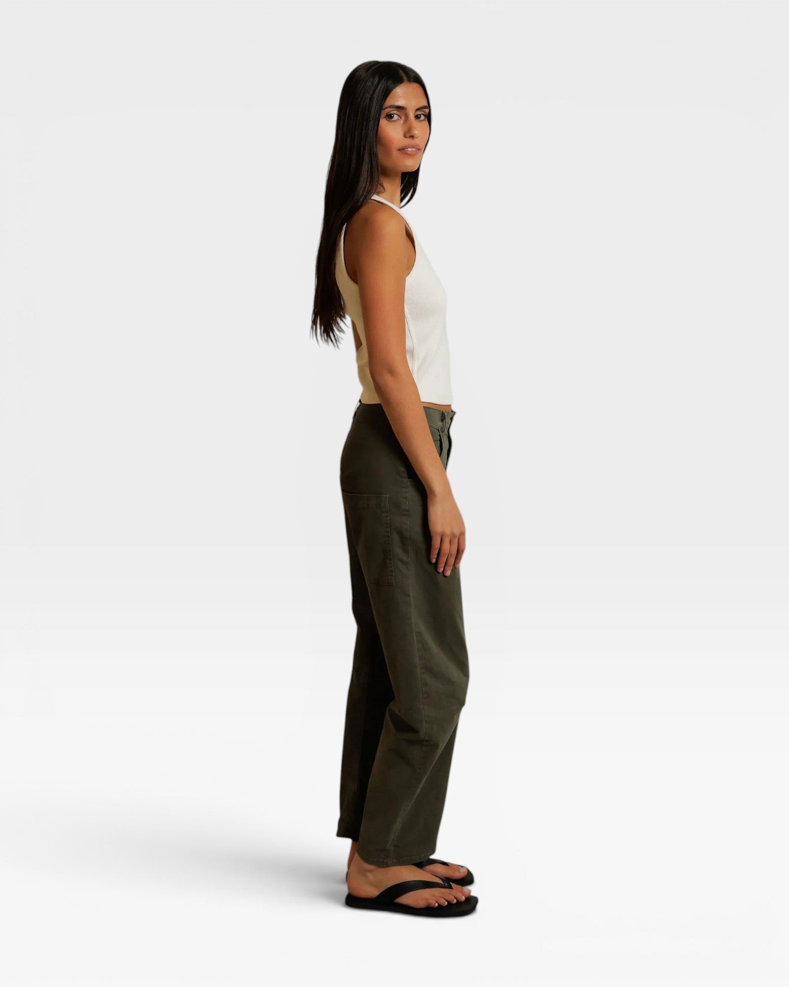 JONES + CO Blondie bright ivory ribbed tank top worn by a model in profile with olive green pants and sandals.