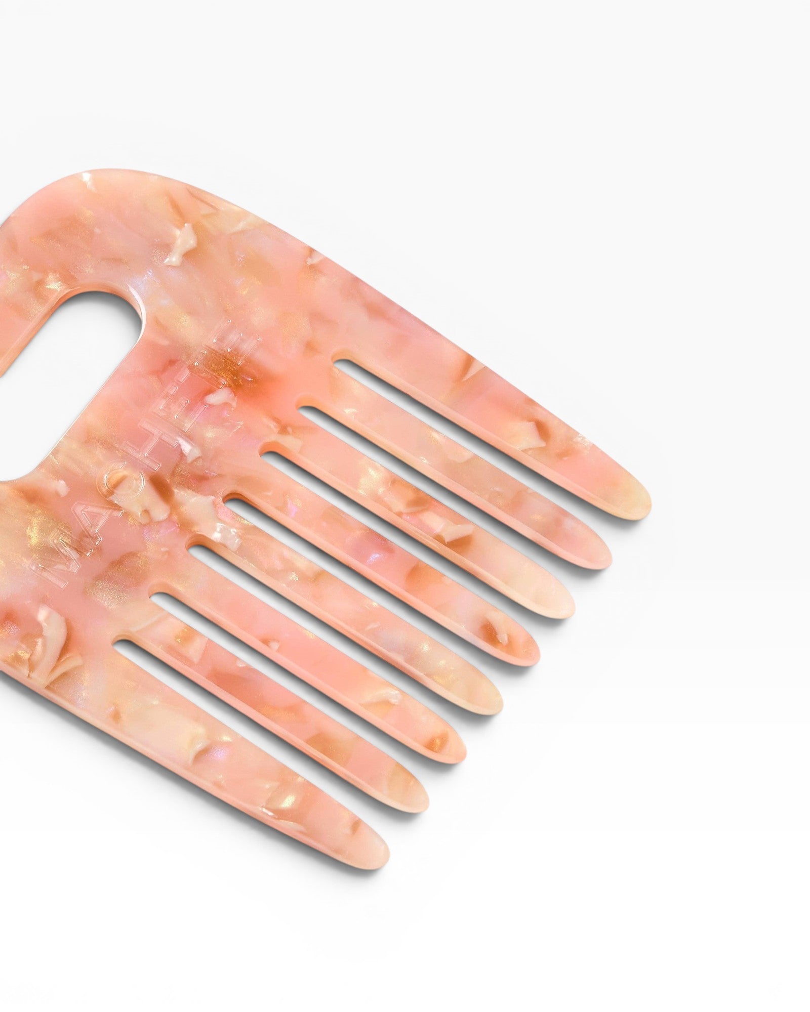 JONES + CO No. 4 Comb in Blossom, a wide-tooth comb handmade from Italian acetate with a marbled pink and gold finish.