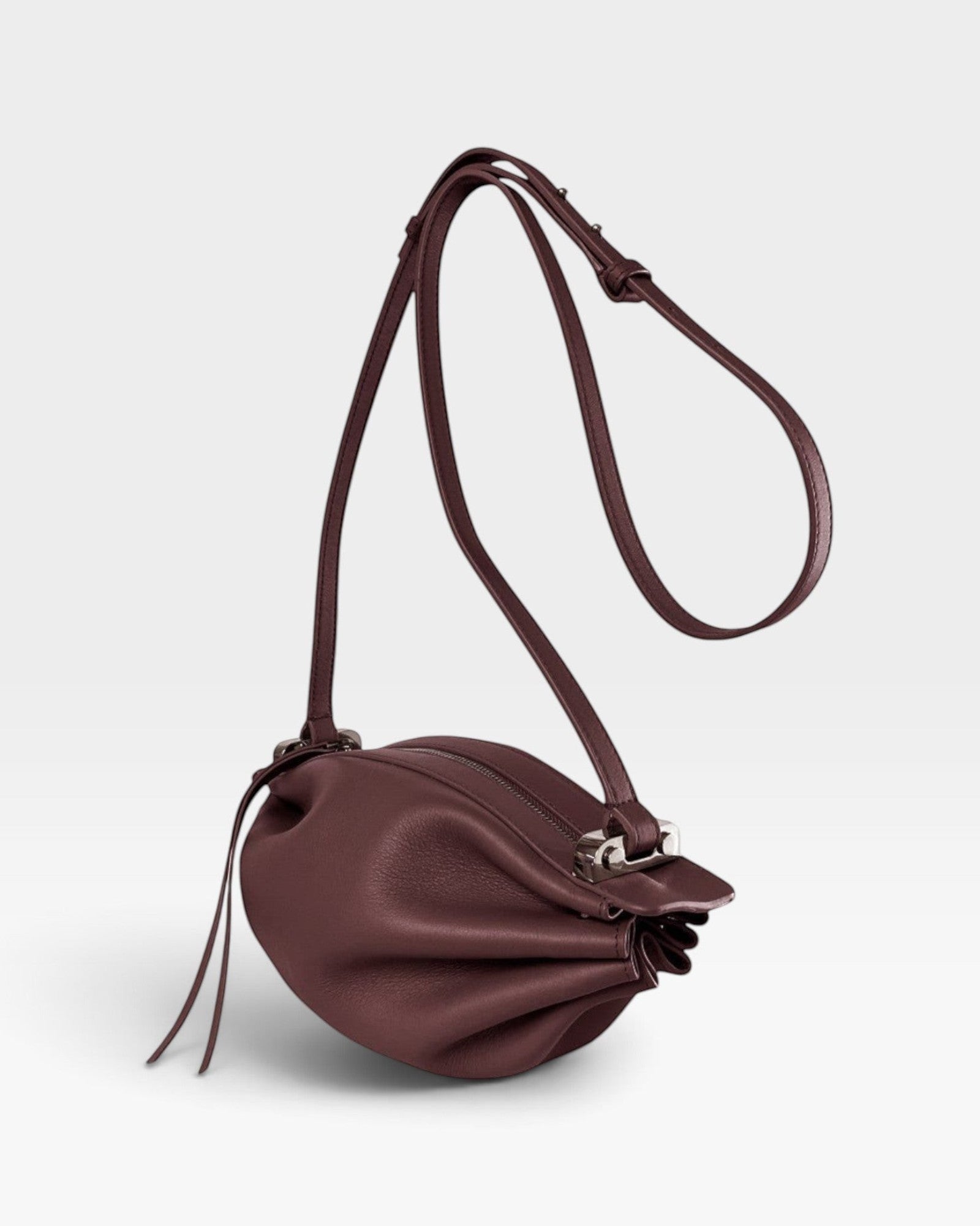 JONES + CO Bon-Bon wine red calf leather shoulder bag with pleated ends, adjustable strap, and silver brass hardware.