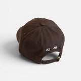 JONES + CO brown baseball cap with white embroidered logo on the back and adjustable metal strap closure