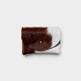 JONES + CO brown and white cowhide cardholder with a solid brass fastener, perfect for cards and cash.