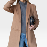 JONES + CO camel wool cashmere tailored coat with notch collar worn by a model with a grey sweater and blue jeans