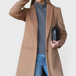 JONES + CO camel wool cashmere tailored coat with notch collar worn by a model with a grey sweater and blue jeans