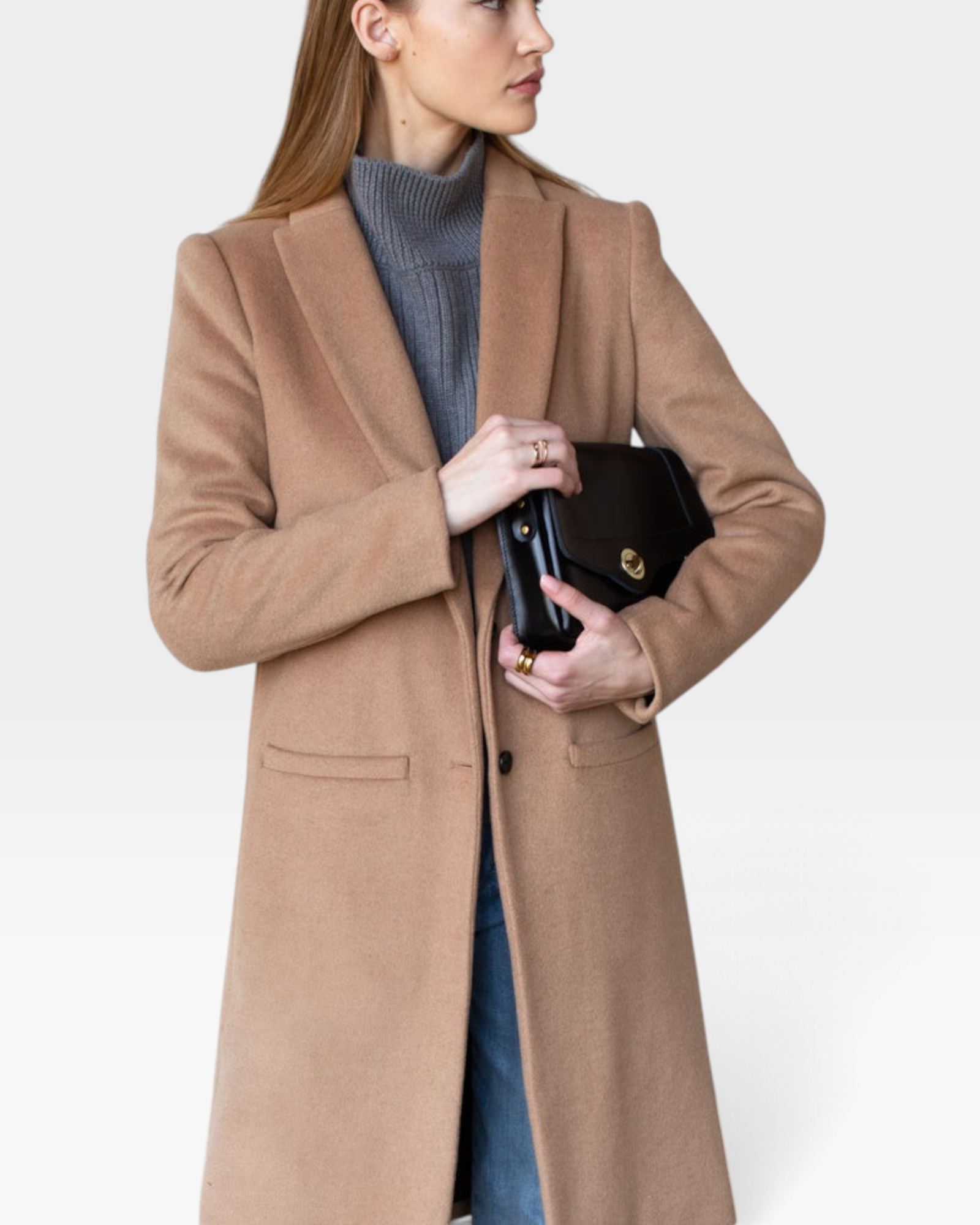 JONES + CO camel wool cashmere tailored coat with notch collar worn over a grey turtleneck and blue denim jeans.