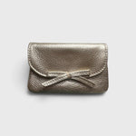 JONES + CO champagne metallic leather petite case featuring a delicate knotted bow on the front flap.