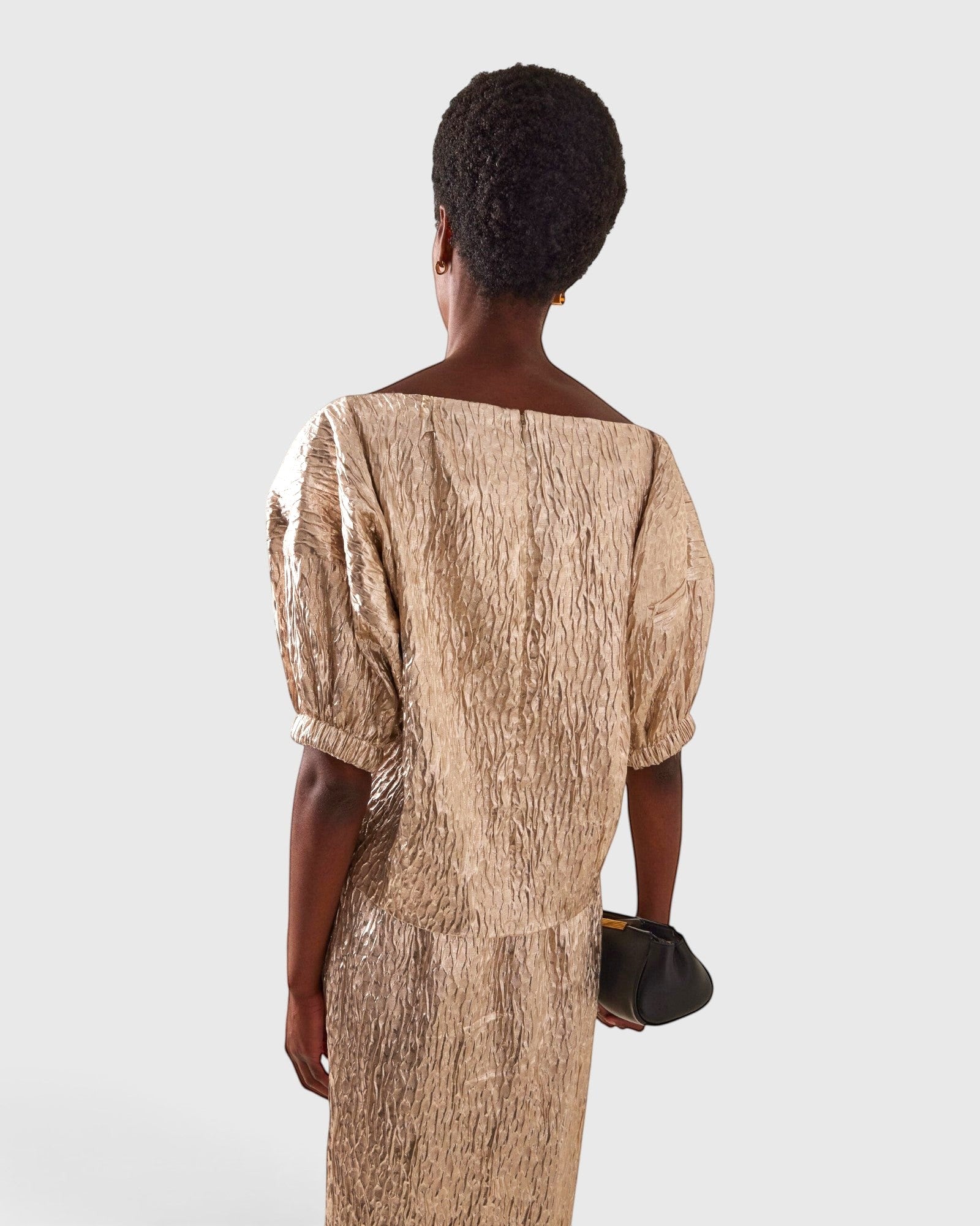 JONES + CO Filly Top in champagne shimmery textured silk with a boat neckline and puff sleeves, rear view.