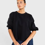 Model wearing a charcoal JONES + CO Rachel Comey Fond sweatshirt with drop shoulders and raw edge hemline