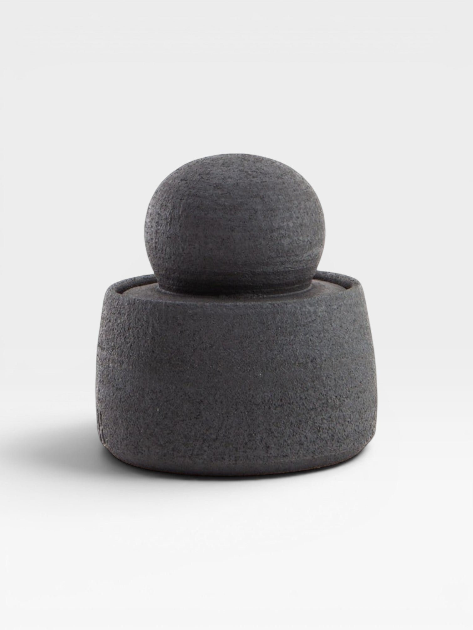 JONES + CO matte charcoal stoneware stash jar with a large chunky knob. Hand-thrown, textured exterior, glossy interior.