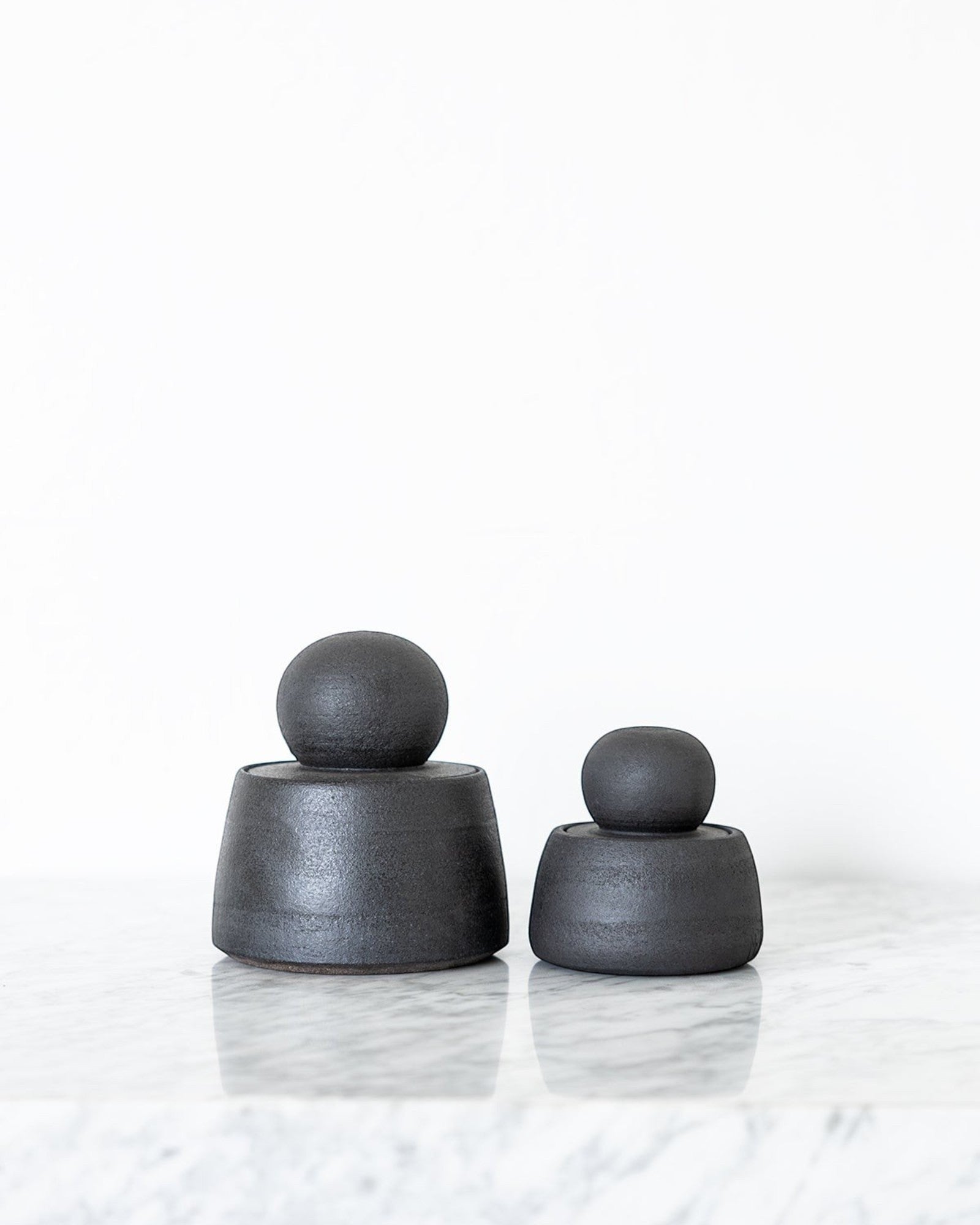 JONES + CO matte charcoal stoneware stash jars with chunky knobs, perfect for organization.