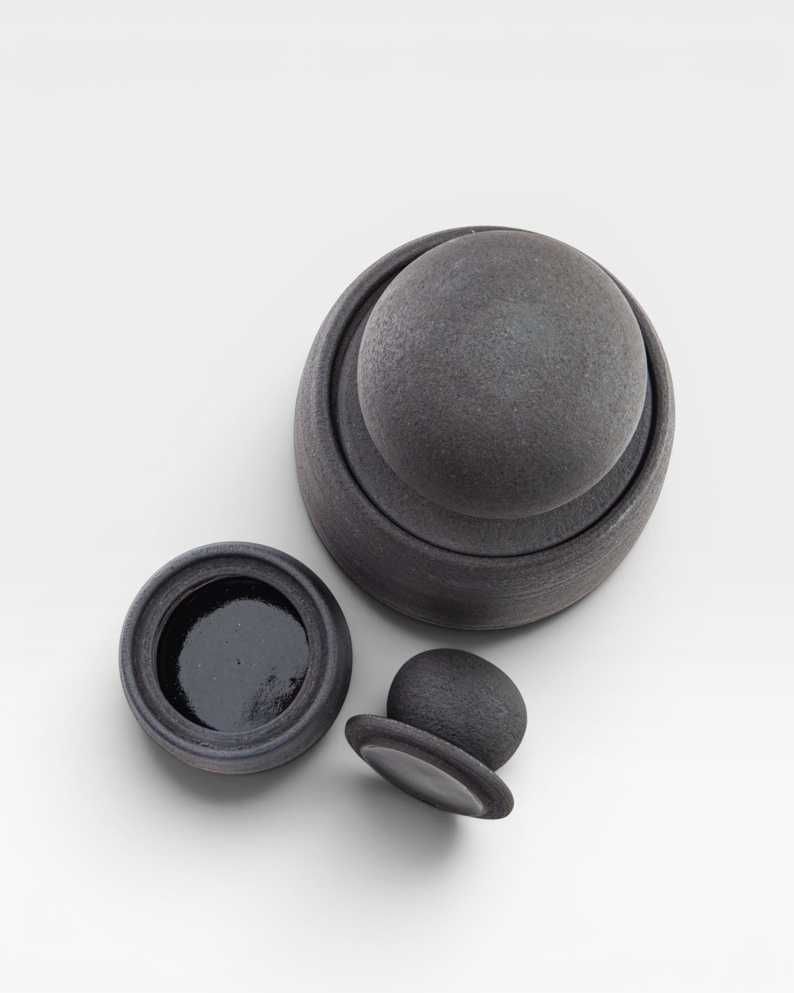 JONES + CO matte charcoal stoneware stash jar with chunky knob lid and glossy black interior. Hand-thrown ceramic.