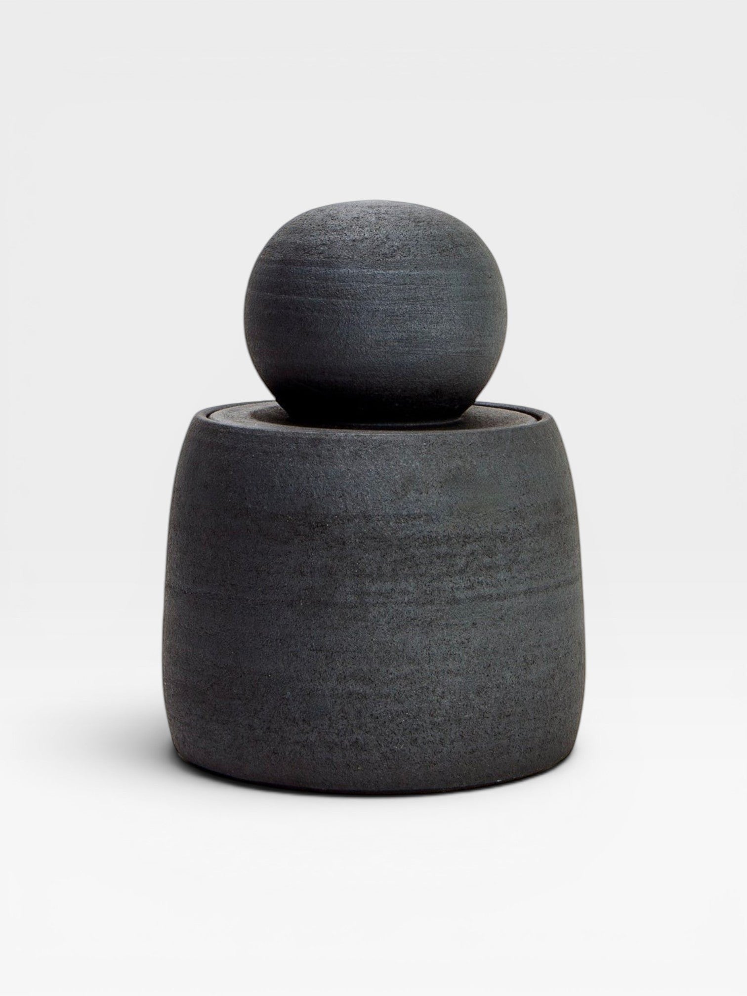 JONES + CO matte charcoal stoneware stash jar with a chunky knob lid. Handmade, textured exterior and glossy interior.