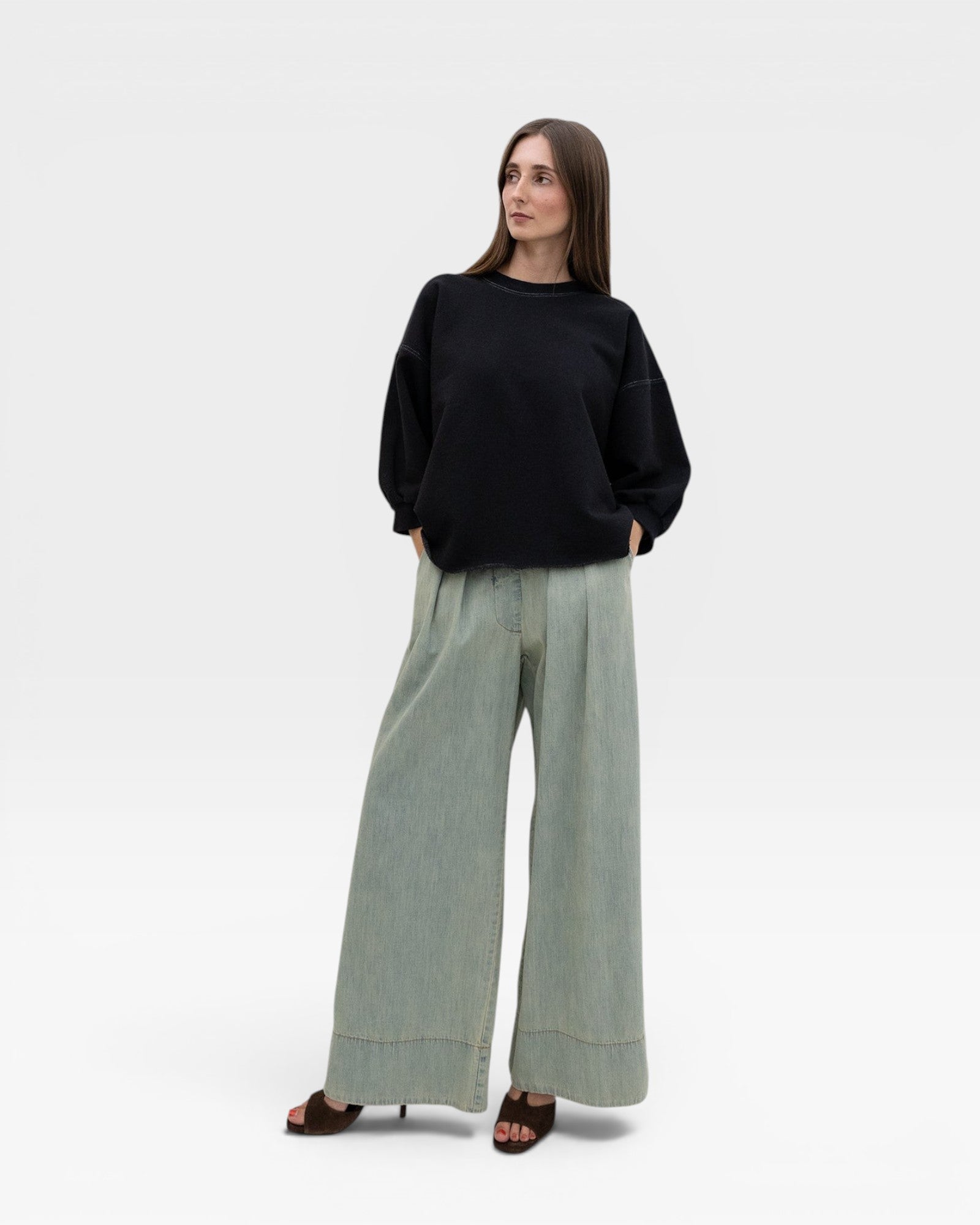 JONES + CO charcoal crewneck sweatshirt with drop shoulders, raw edge hem, and distressing. Model wears wide-leg jeans.