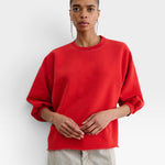 JONES + CO Rachel Comey Fond crewneck sweatshirt in cherry red with drop shoulders and raw edge hem on a model