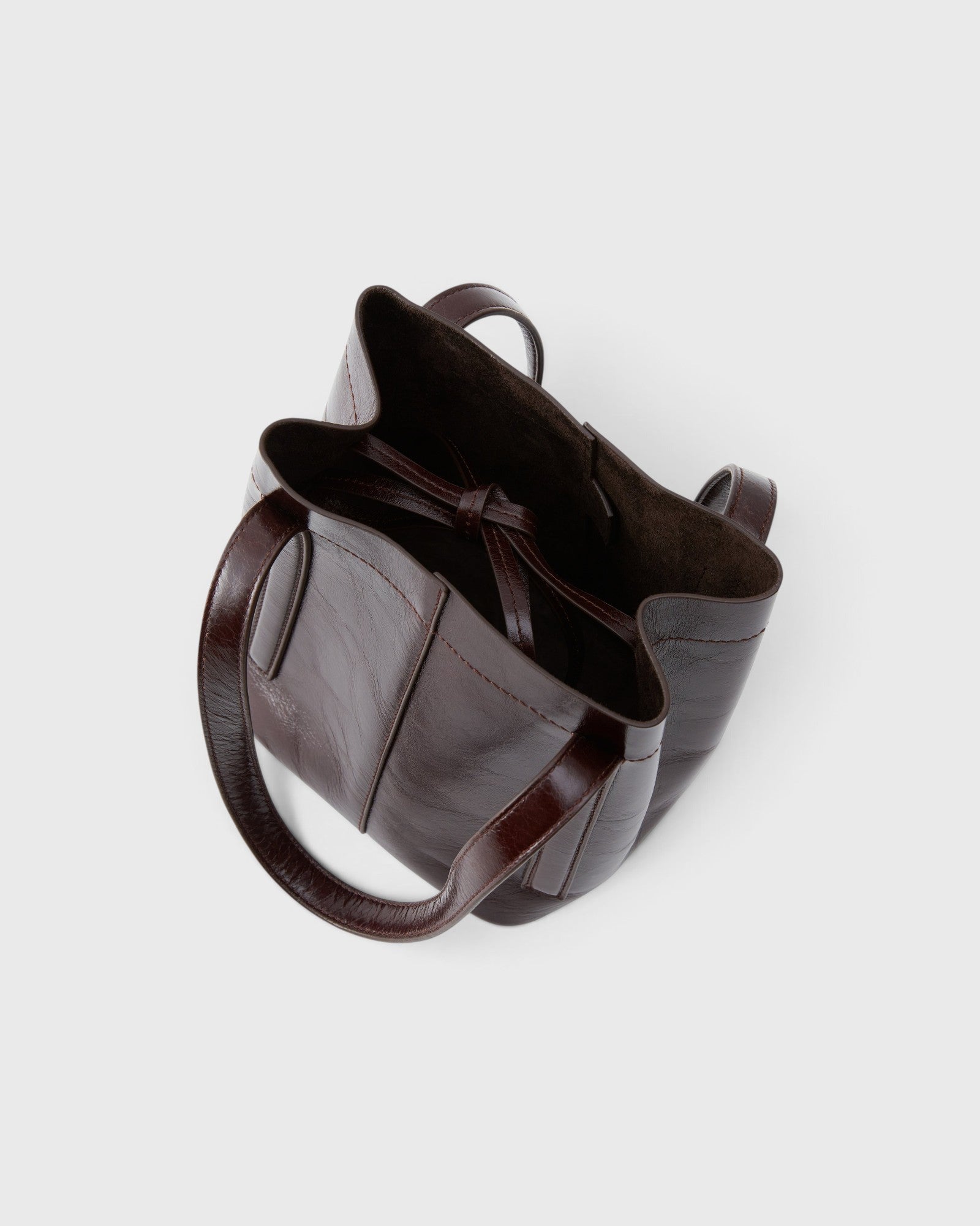 JONES + CO Bucket Tool bag in chestnut lustre leather with vertical paneling, sturdy handles, and internal tie closure.