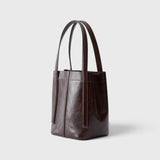 JONES + CO Bucket Tool bag in chestnut lustre leather with vertical paneling, elongated handles, and open top design.