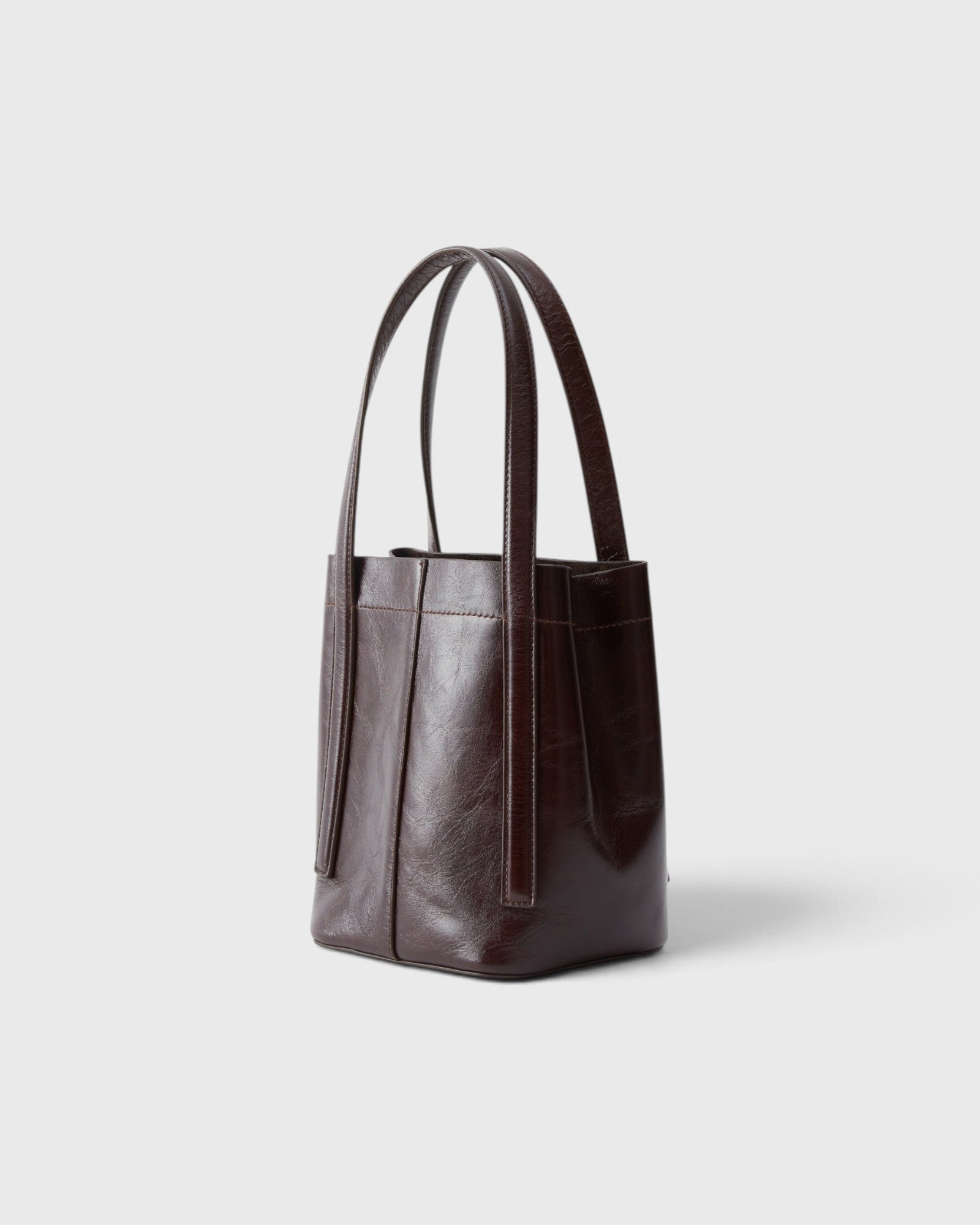 JONES + CO Bucket Tool bag in chestnut lustre leather with vertical paneling, elongated handles, and open top design.