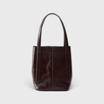JONES + CO Bucket Tool bag in chestnut lustre leather with vertical paneling and elongated shoulder handles.