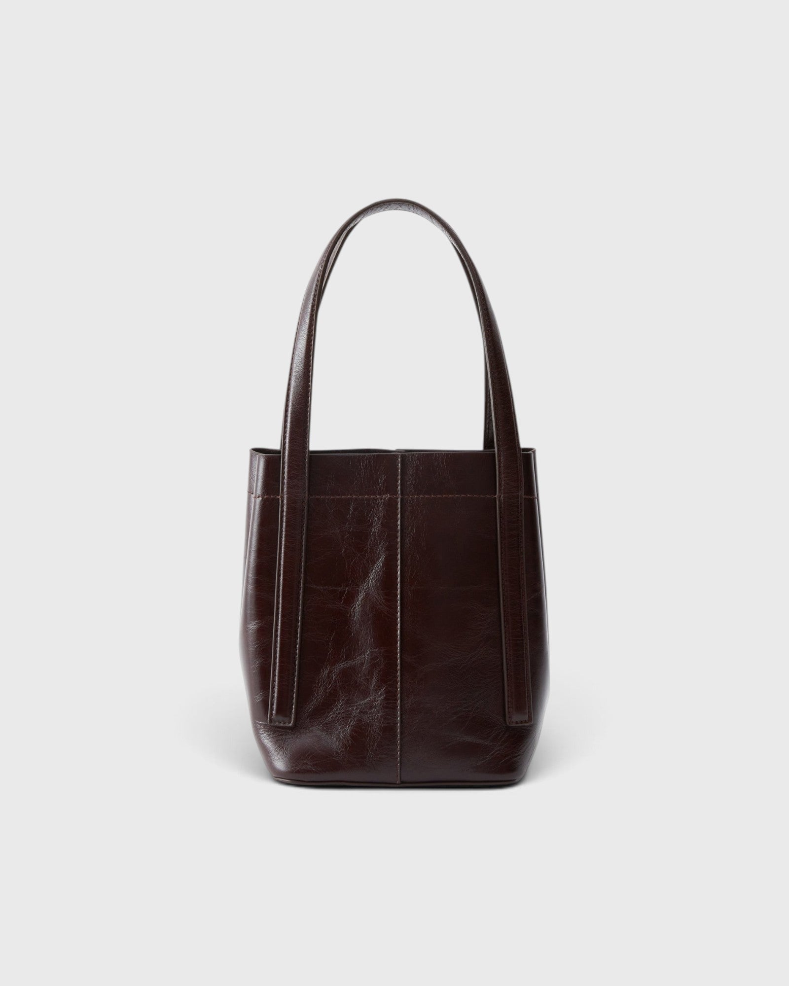 JONES + CO Bucket Tool bag in chestnut lustre leather with vertical paneling and elongated shoulder handles.