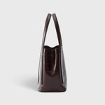 JONES + CO Bucket Tool bag in chestnut lustre leather with vertical paneling and elongated handles, side view.