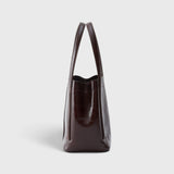 JONES + CO Bucket Tool bag in chestnut lustre leather with vertical paneling and elongated handles, side view.