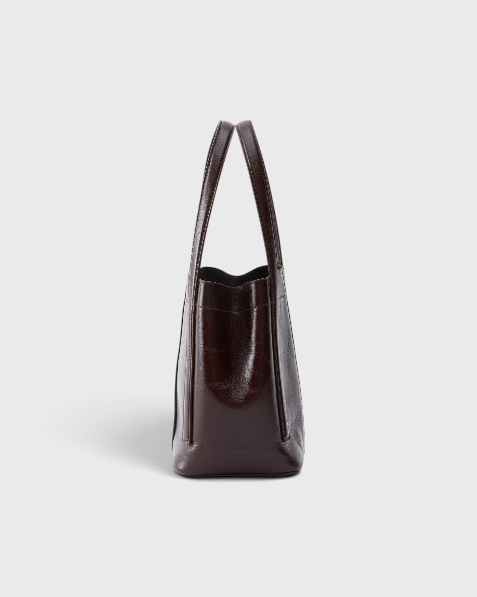 JONES + CO Bucket Tool bag in chestnut lustre leather with vertical paneling and elongated handles, side view.