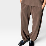 JONES + CO chocolate brown heavy cotton balloon pants with elastic cuffs and side pockets on a model