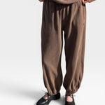 JONES + CO chocolate brown heavy cotton balloon pants with elastic cuffs and side pockets on a model